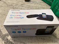Box of Memorex Travel Speaker showing brand, product name, and image of speaker with iPhone docked.