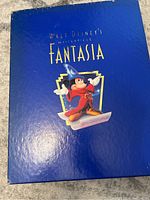 Closed blue outer slipcover box with gold lettering and Sorcerer Mickey image.