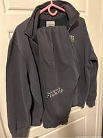 Full tracksuit laid on a hanger showing sweatshirt and sweatpants with visible logos.