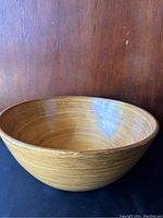 Front angle view of a large bamboo bowl showing smooth polished inner and outer surfaces and natural bamboo grain.