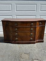 Front view of crotch mahogany serpentine front sideboard showing drawers and cabinet doors.