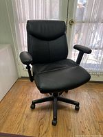 Front view of the black office chair showing padded seat, backrest, and armrests.