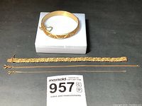 Four bracelets laid flat with auction tag