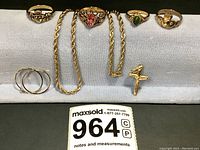 All seven pieces displayed together: chain, rings, earrings and pendant