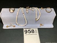 Display of all seven jewelry pieces on gray velvet stand