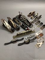 Four complete woodworking planes with wooden handles along with assorted plane parts and two machinists levels and two draw knives.