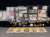 Wide view of multiple plastic pages containing vintage sports tickets, assorted pins (Detroit Tigers, Buffalo Sabres, Others), and several Boston Red Sox team patches in sealed packaging.