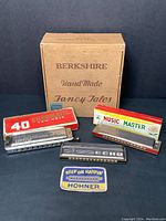 Photo listing all harmonicas with boxes, patch, and storage box showing entire lot