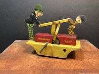 Front view showing both figures on yellow base with red windup block