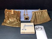 Overview of two gold-tone mesh purses, chain necklace with pendants, and original box