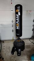 FITVEN branded free standing punching bag with weighted base and boxing gloves placed at base