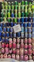 Full rack showing spools of green and blue embroidery thread arranged neatly