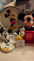 Photo showing the metal tray with Mickey Mouse image, plush photo frame, soap dish and toothbrush holder.