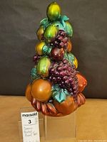 Front view of ceramic fruit tree with visible apples, grapes, and other fruits.