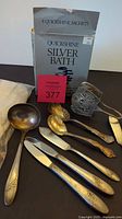 Full view of lot showing silverplate utensils, Quickshine Silver Bath sachet box, and polishing gloves