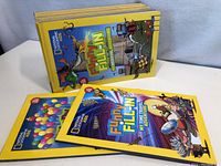 Group of 16 National Geographic Kids Funny Fill-In books stacked showing colorful cartoon covers and yellow borders.