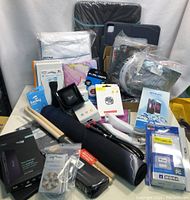 Full lot view displaying a variety of new electronic accessories packed together including packaging for wireless earbuds, screen replacements, controllers, and cases.