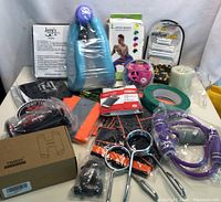 Wide shot showing all fitness items in the lot including hand grips, resistance bands, tape, and strength trainers