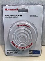 Front view of Honeywell Water Leak Alarm in sealed blister packaging showing product and branding.