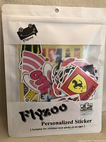 Front of resealable plastic packaging showing assorted stickers inside with visible colorful designs and branding 'Flyzoo'