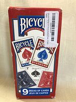 Nine decks of Bicycle brand playing cards in sealed original packaging with red and blue designs.