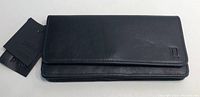 Front view of the new Pelle women's black leather wallet showing embossed logo and attached tags.