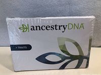 Front view of sealed AncestryDNA + Traits kit box showing brand and design.