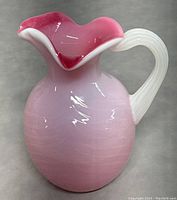 Front angle of Murano opaline glass pitcher showing pink gradient and white handle.