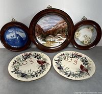 Overall photo of all five plates, including three framed wall plates and two Lenox Winter Greetings plates, showing design details and condition.
