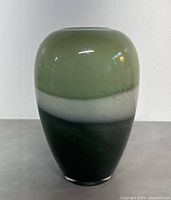 Front view of the rounded MCM art glass vase showing layered colors of olive green, white, and dark green/black.