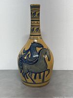 Front view showing two horses painted in blue and gray on beige pottery with decorative bands at base and neck.