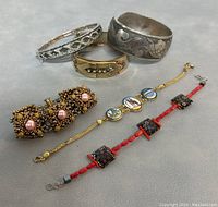 Photo showing all six pieces of jewelry: three bangles and three bracelets with various materials and designs.