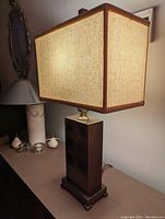 Front view of the Asian influenced table lamp showing rectangular fabric shade and visible wooden base.