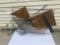 Front left angled view showing corrugated copper-tone panels, black rods, circular loops, and silver-tone accents.