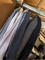 Six items (four shirts and two sport coats) hanging on rod