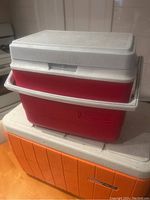 Stacked coolers showing three sizes and colors with lids on, taken under indoor lighting