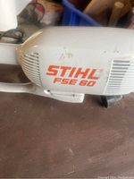 Close-up of Stihl FSE 60 electric trimmer motor housing showing brand and model.