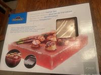 Box showing Napoleon brand Himalayan Salt Platter set with images of cooking scallops on salt block.