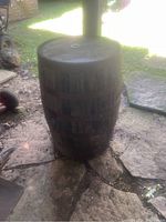 Front angle view of the oak wine barrel showing its closed top and metal bands.