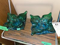 Two blue-green vintage Mid-Century Modern art glass bowls shown side by side on a wooden surface.