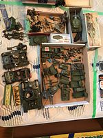 Overview of multiple die-cast vehicles, toy soldiers and accessories laid out