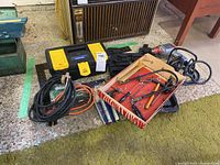 Wide shot of all tools on concrete floor showing Dremel Multi Pro case, power tools, hand tools box and socket set case.