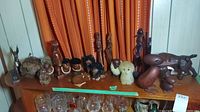 Wide shot of multiple wood and rope figurines on tabletop