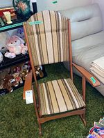 Full view of wooden folding rocking chair showing striped upholstery and rocking base