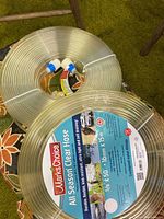 Two rolls of clear Mark's Choice All Season Hose, each roll showing label and fittings.