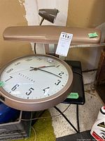 Westclox wall clock and beige desk lamp on a black surface