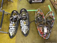 Pair of snow shoes: one black Atlas 8.25 Trail and one GV with graphic design, visible bindings and straps.