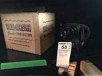 Photo of vintage black plastic Sawyer's View-Master Junior Projector beside original box showing branding and condition