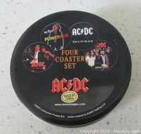 Round metal tin top showing AC/DC logo, album cover and band images, and text 'Four Coaster Set'