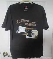 Full view of black T-shirt featuring front design with 'Eric Clapton & Jeff Beck' text and two electric guitar graphics.
